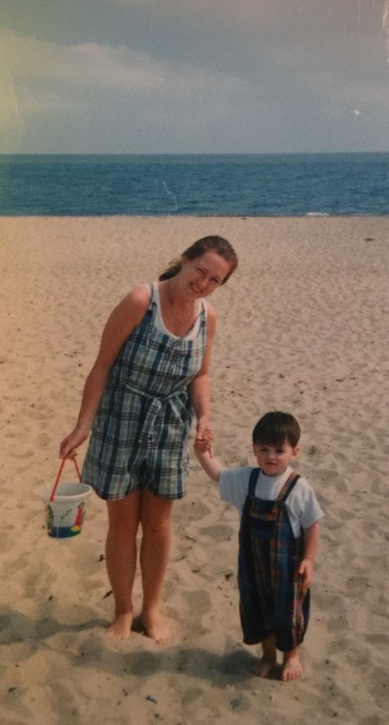 Mum and child at the beach with a bucket